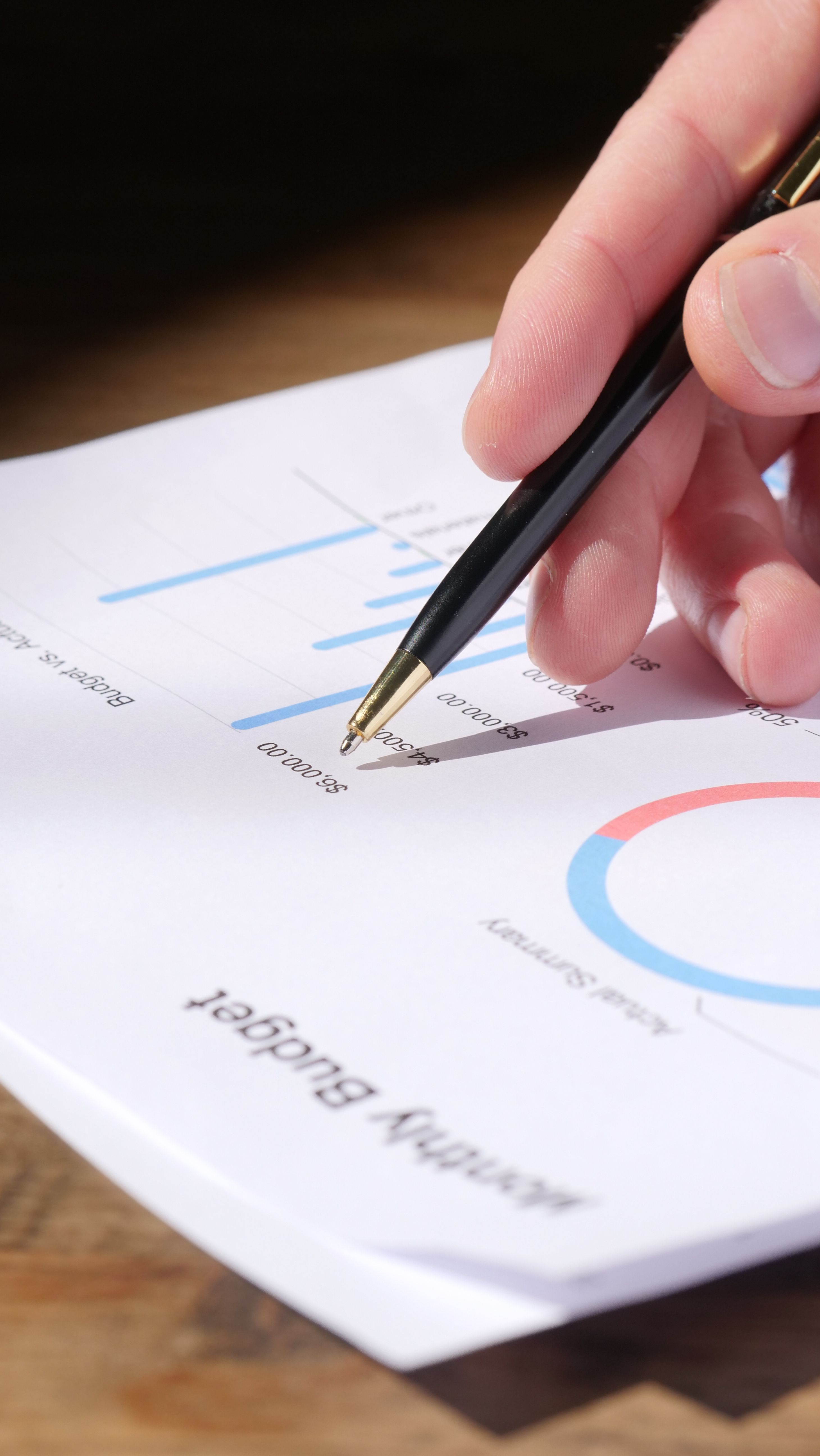 Overhead view of someone reviewing paperwork and running the numbers with a calculator